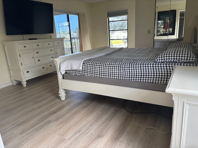 bedroom featuring multiple windows and light wood-style flooring