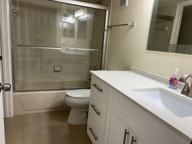 bathroom with toilet, enclosed tub / shower combo, visible vents, tile patterned floors, and vanity