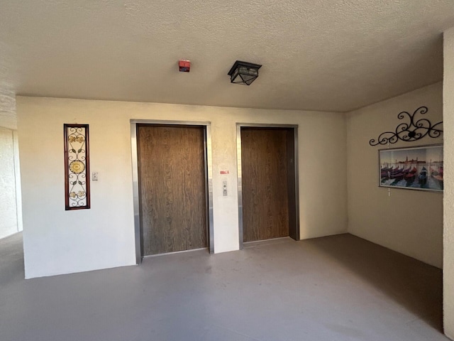 unfurnished bedroom with a textured ceiling and finished concrete flooring