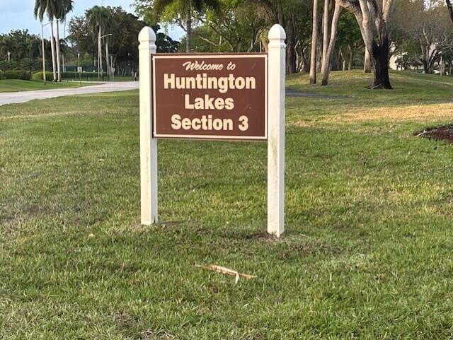 community sign featuring a yard