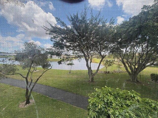 view of home's community featuring a yard, fence, and a tennis court