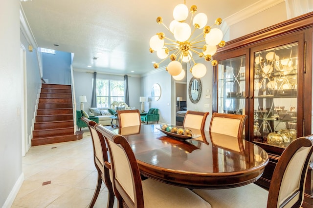 dining room with a notable chandelier, baseboards, ornamental molding, light tile patterned flooring, and stairs