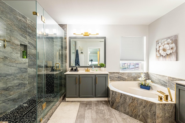full bath featuring vanity, a bath, a stall shower, and wood finished floors
