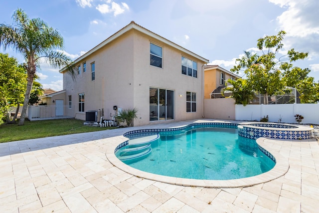 view of pool with central AC, a pool with connected hot tub, a lawn, a fenced backyard, and a patio