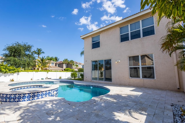 view of pool featuring a fenced backyard, a pool with connected hot tub, and a patio