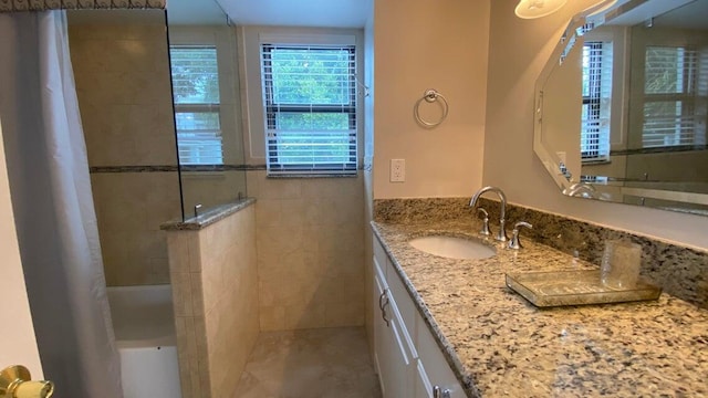 bathroom featuring shower / bath combo with shower curtain and vanity