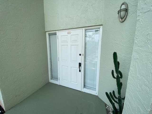 entrance to property featuring stucco siding