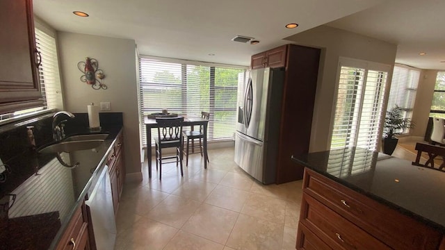 kitchen featuring a sink, light tile patterned flooring, dishwasher, stainless steel fridge with ice dispenser, and recessed lighting