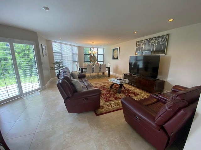 living area featuring baseboards, a chandelier, and plenty of natural light