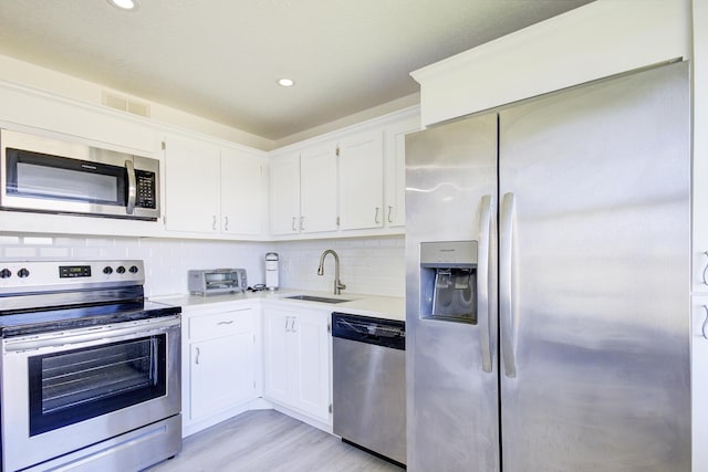 11 Colonial Club Dr Unit 302, Boynton Beach, FL 33435 - kitchen featuring stainless steel appliances, a sink, light countertops, backsplash, and white cabinetry