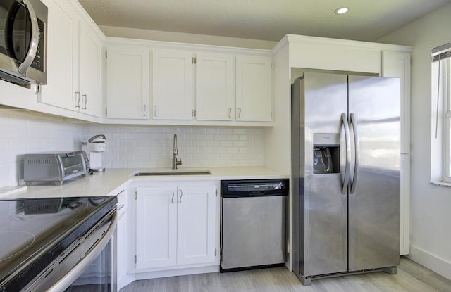 11 Colonial Club Dr Unit 302, Boynton Beach, FL 33435 - kitchen featuring stainless steel appliances, a sink, light wood finished floors, white cabinetry, and light countertops