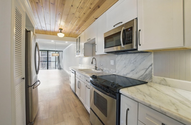 kitchen featuring white cabinets, appliances with stainless steel finishes, wooden ceiling, and decorative backsplash