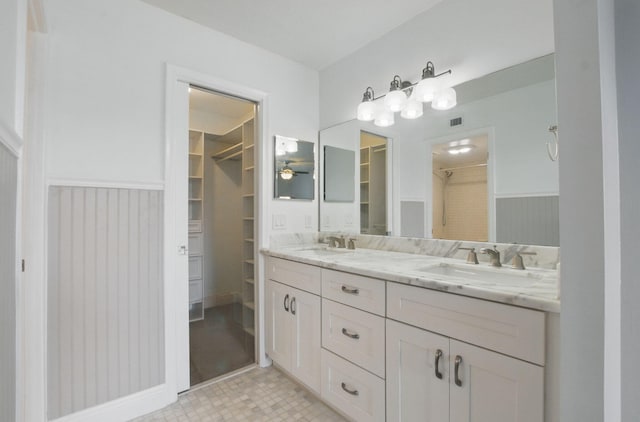 bathroom featuring a wainscoted wall, a sink, and a ceiling fan