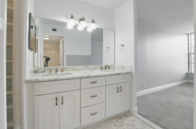bathroom with double vanity, visible vents, baseboards, and a sink