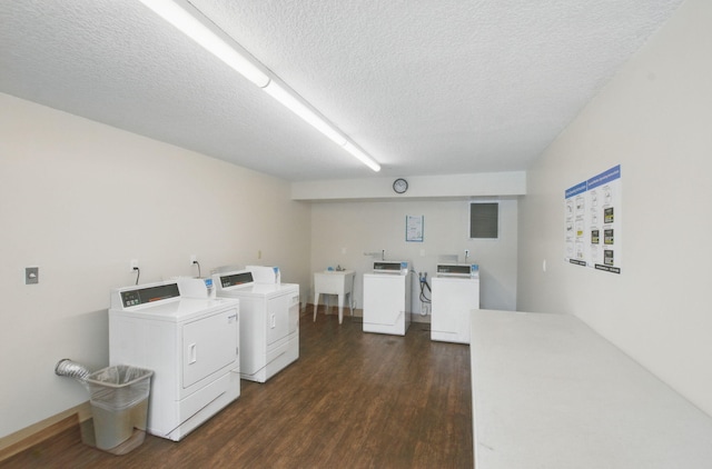 common laundry area with dark wood finished floors, washer and dryer, a textured ceiling, and a sink