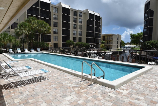 pool with a patio and fence