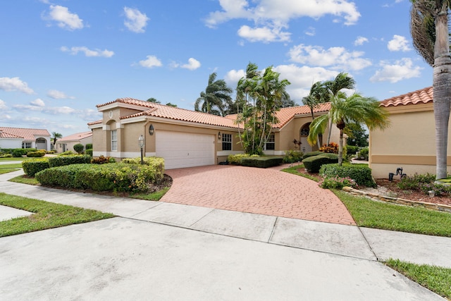 8004 Copenhagen Way, Boca Raton, FL 33434 - mediterranean / spanish-style house with decorative driveway, a garage, a tile roof, and stucco siding
