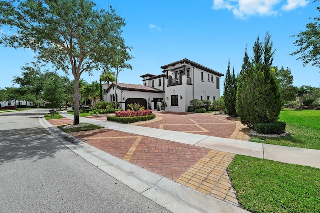 9650 Eden Mnr, Parkland, FL 33076 - mediterranean / spanish-style house featuring an attached garage, a front lawn, a tile roof, stucco siding, and decorative driveway