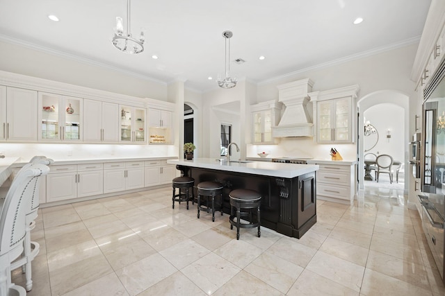 9650 Eden Mnr, Parkland, FL 33076 - kitchen with arched walkways, light countertops, premium range hood, a notable chandelier, and a breakfast bar
