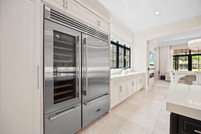 9650 Eden Mnr, Parkland, FL 33076 - kitchen with light countertops, built in fridge, ornamental molding, and a healthy amount of sunlight