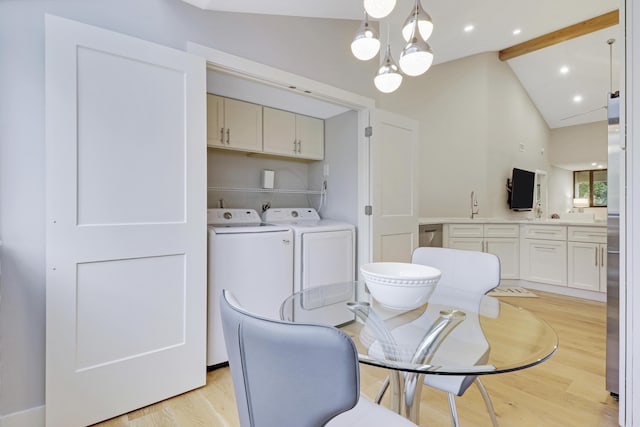 dining space with lofted ceiling with beams, an inviting chandelier, washing machine and dryer, and light wood-type flooring