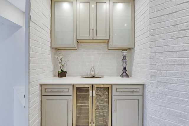 bar featuring indoor wet bar, beverage cooler, and backsplash