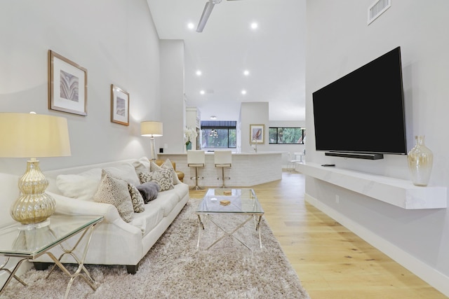 living area featuring recessed lighting, wood finished floors, visible vents, and baseboards