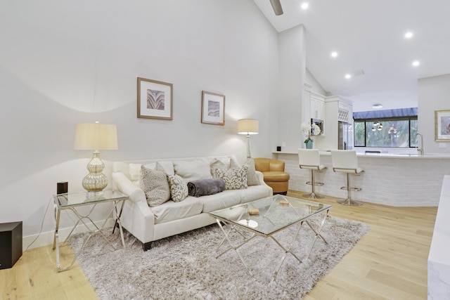 living room featuring recessed lighting, light wood-style floors, and high vaulted ceiling