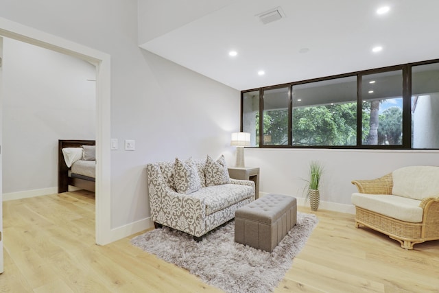 sitting room featuring visible vents, baseboards, wood finished floors, and recessed lighting