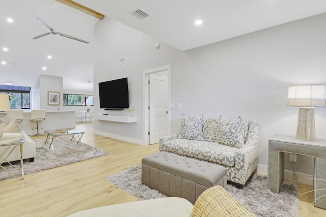 living room with wood finished floors, visible vents, a ceiling fan, and high vaulted ceiling