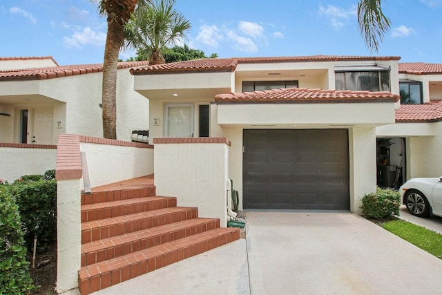 mediterranean / spanish home featuring stucco siding, driveway, and a tiled roof