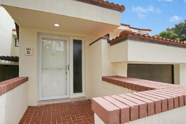 doorway to property with a tiled roof and stucco siding