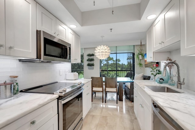5279 Fountains Dr S Unit 304, Lake Worth, FL 33467 - kitchen featuring appliances with stainless steel finishes, a sink, white cabinets, decorative backsplash, and recessed lighting