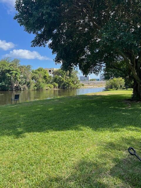 view of green lawn featuring a water view