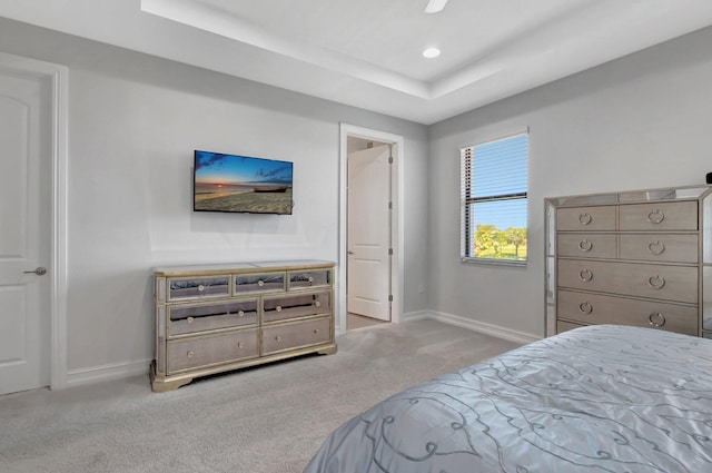 carpeted bedroom featuring a ceiling fan, baseboards, recessed lighting, and a tray ceiling