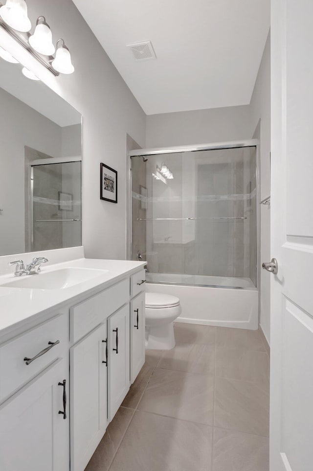 full bath with toilet, vanity, visible vents, and combined bath / shower with glass door