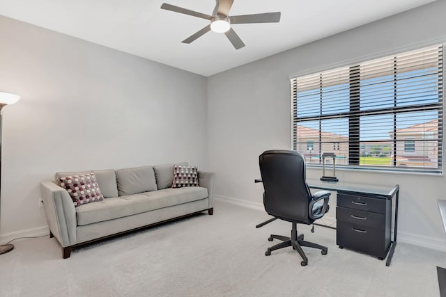 home office featuring light colored carpet, ceiling fan, and baseboards