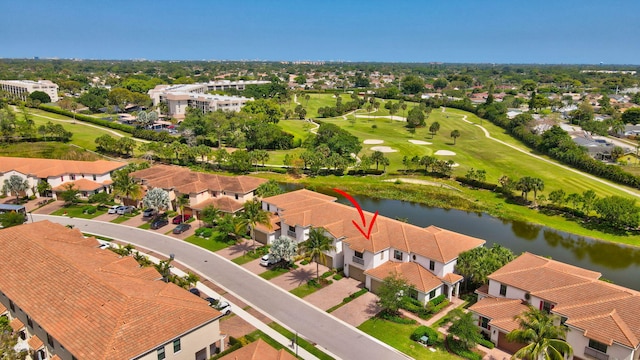 aerial view with golf course view and a water view