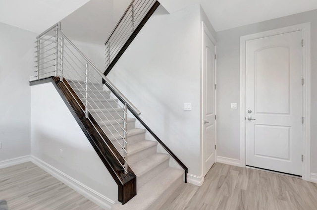 stairs with baseboards and wood finished floors