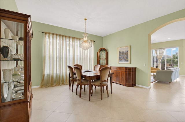 6863 Imperial Beach Cir, Delray Beach, FL 33446 - dining space featuring arched walkways, a chandelier, light tile patterned floors, and baseboards