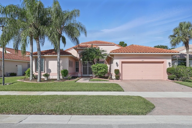 477 NW Blue Lake Dr, Port Saint Lucie, FL 34986 - mediterranean / spanish-style house featuring an attached garage, decorative driveway, a front yard, stucco siding, and a tile roof