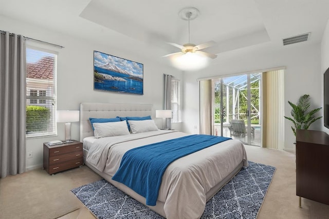 477 NW Blue Lake Dr, Port Saint Lucie, FL 34986 - bedroom featuring a tray ceiling, light carpet, multiple windows, and baseboards