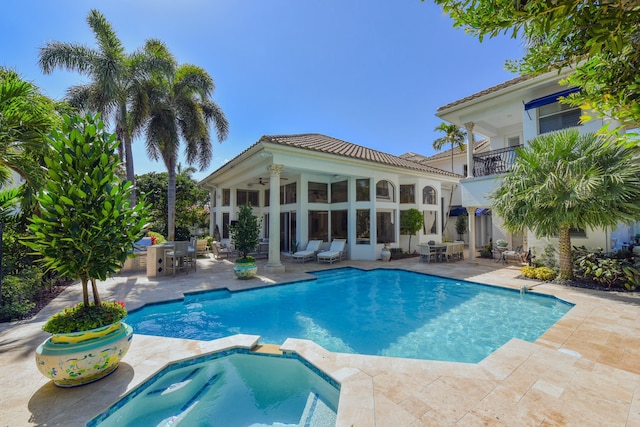view of pool with outdoor dining space, a patio, a pool with connected hot tub, and a ceiling fan