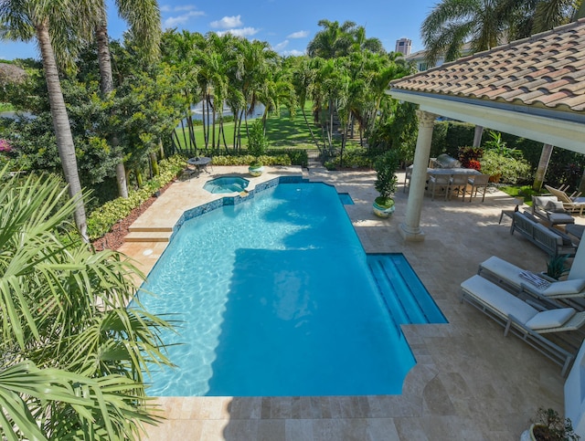 view of swimming pool with a patio, a fenced backyard, a pool with connected hot tub, and outdoor dining area