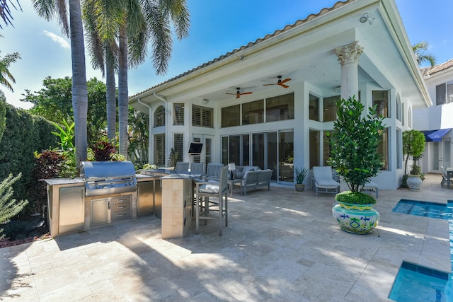 view of patio / terrace featuring a grill, an outdoor pool, and an outdoor kitchen