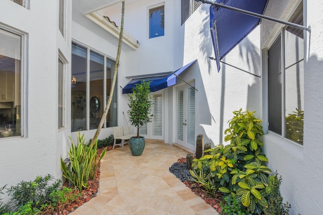 view of property exterior with stucco siding and french doors