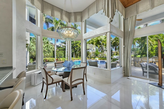 sunroom featuring plenty of natural light and an inviting chandelier
