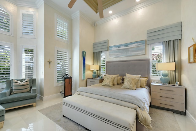 bedroom with a towering ceiling, baseboards, multiple windows, and ornamental molding