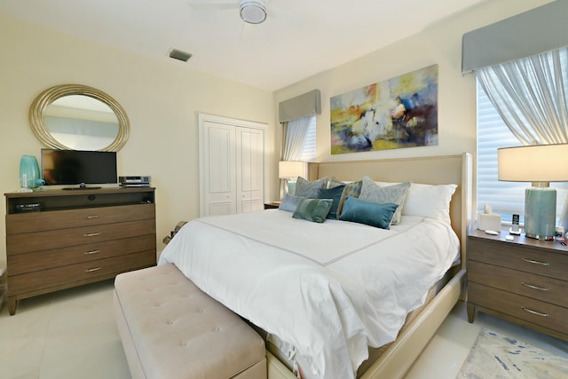 bedroom featuring a closet, light tile patterned floors, multiple windows, and visible vents