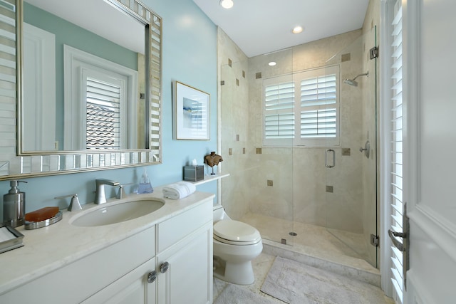 bathroom with a shower stall, recessed lighting, vanity, and toilet